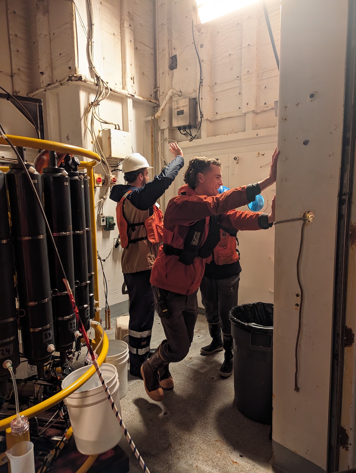 three people demostrating how to shut a door. CTD instrument in foreground