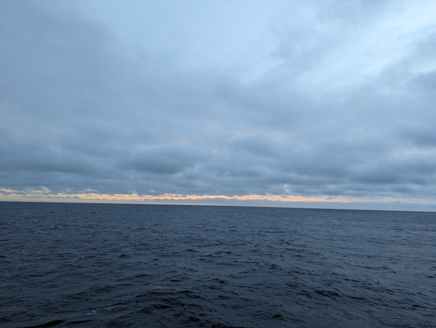 gray clouds over the ocean with the faintest hint of sunset