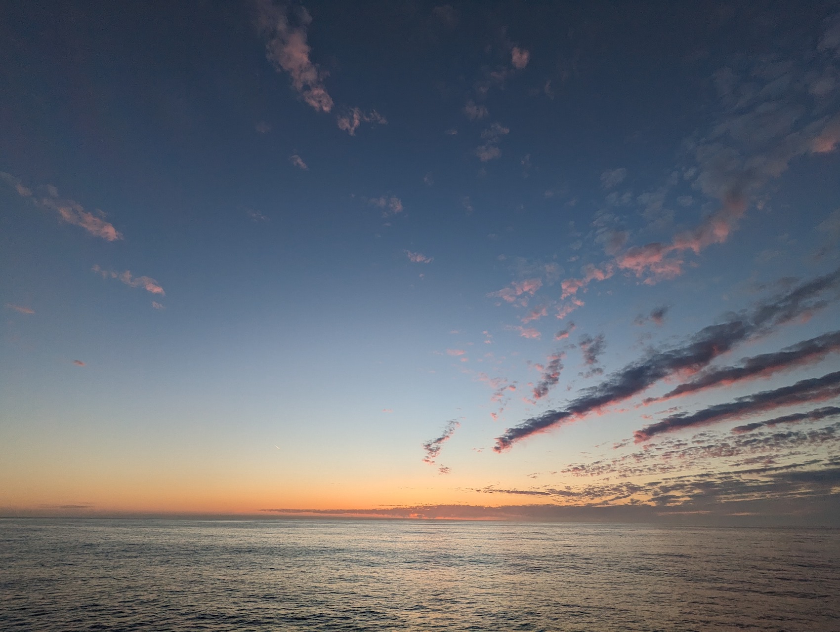 sunset over the pacific ocean, with some pastel streaky clouds
