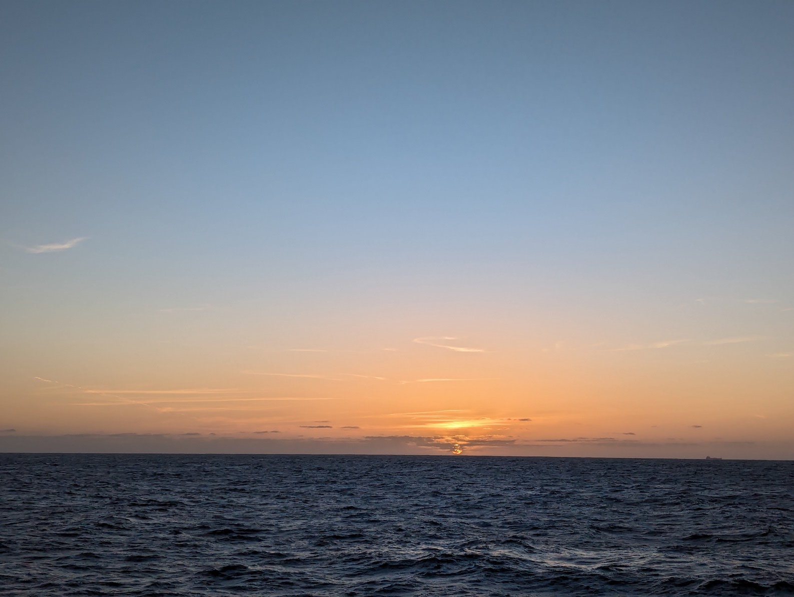 rainbow sunset, with golden sun glow, over the pacific ocean